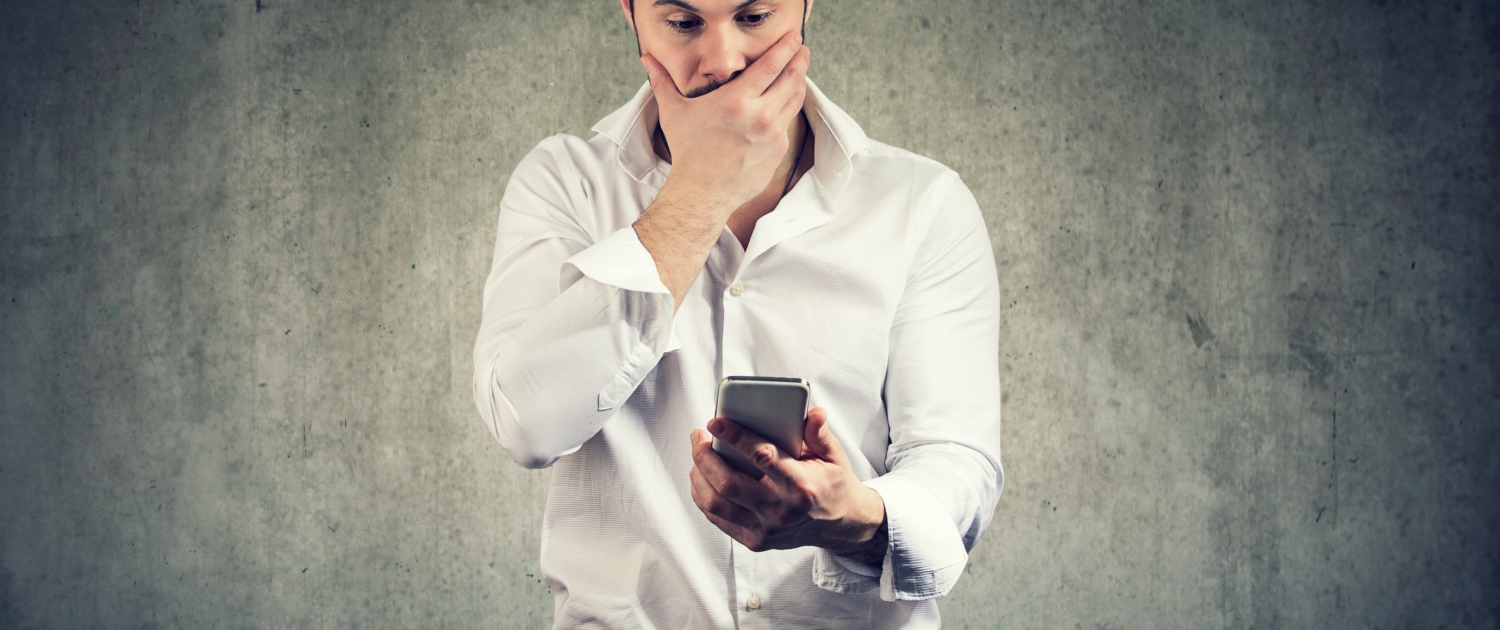 Mann sieht besorgt auf sein Handy